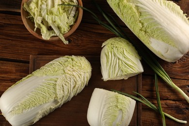 Fresh ripe Chinese cabbages and green onion on wooden table, flat lay