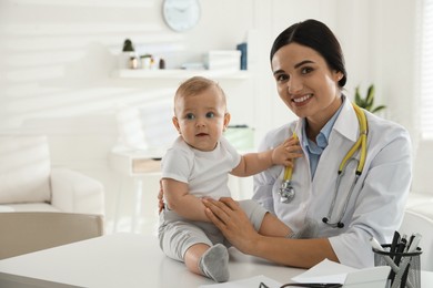 Young pediatrician examining cute little baby in clinic