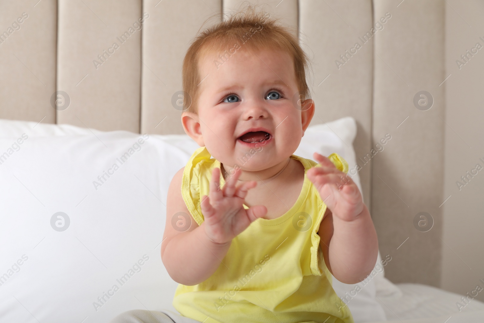 Photo of Cute little redhead baby on bed at home