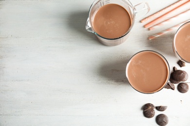 Photo of Flat lay composition with tasty chocolate milk and space for text on wooden background. Dairy drink