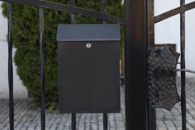 Photo of Black metal letter box on fence outdoors