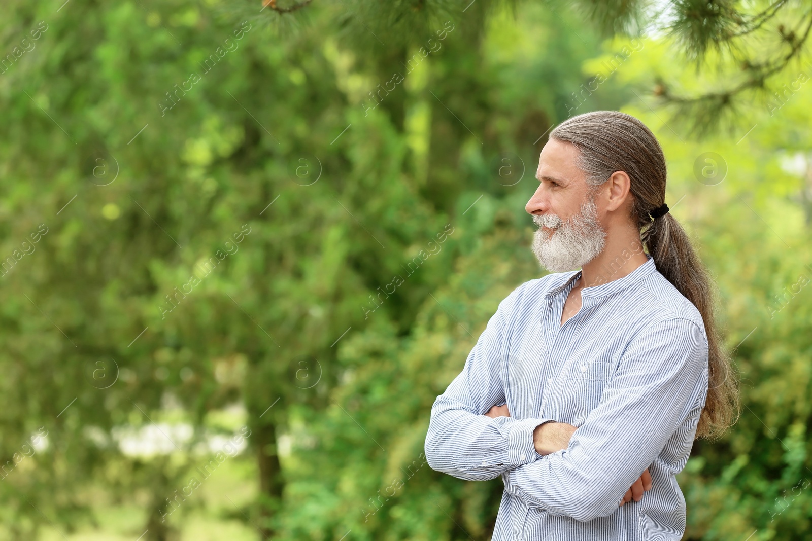 Photo of Handsome bearded mature man in green park