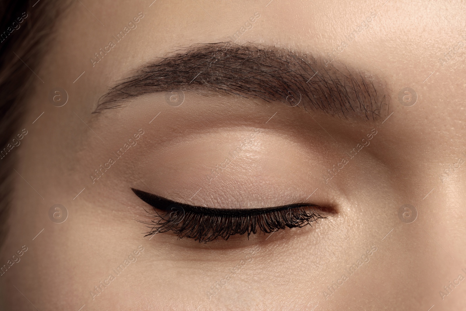 Photo of Young woman with permanent makeup of eyes and brows, closeup