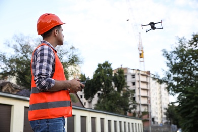 Photo of Builder operating drone with remote control at construction site. Aerial survey
