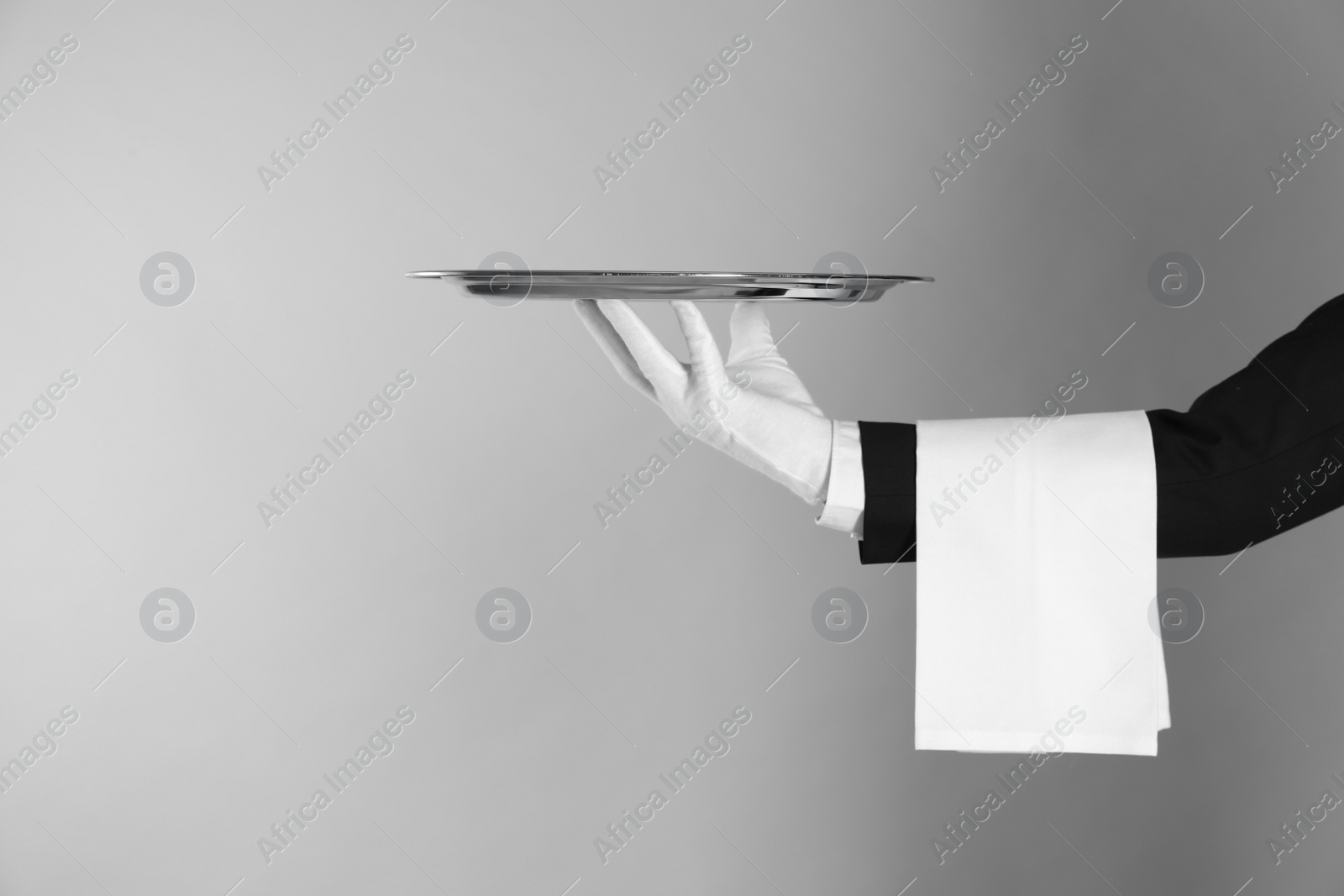 Photo of Butler with tray on light grey background, closeup. Space for text