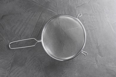 One metal sieve on grey table, top view