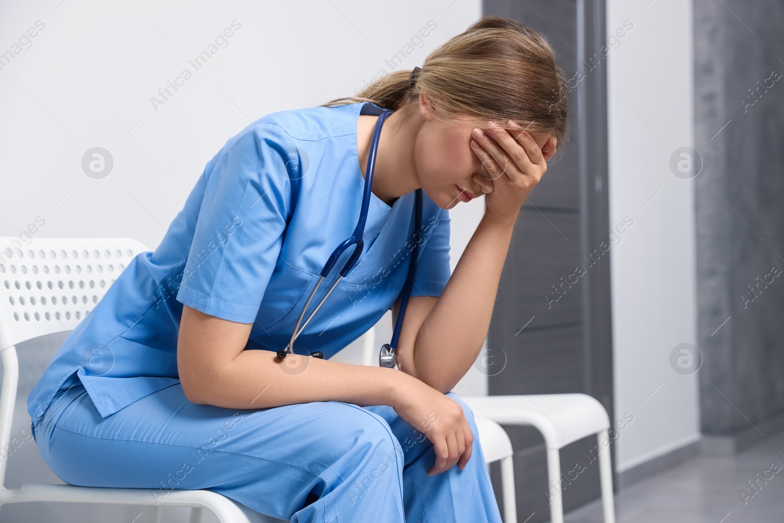 Photo of Exhausted doctor sitting on chair in hospital