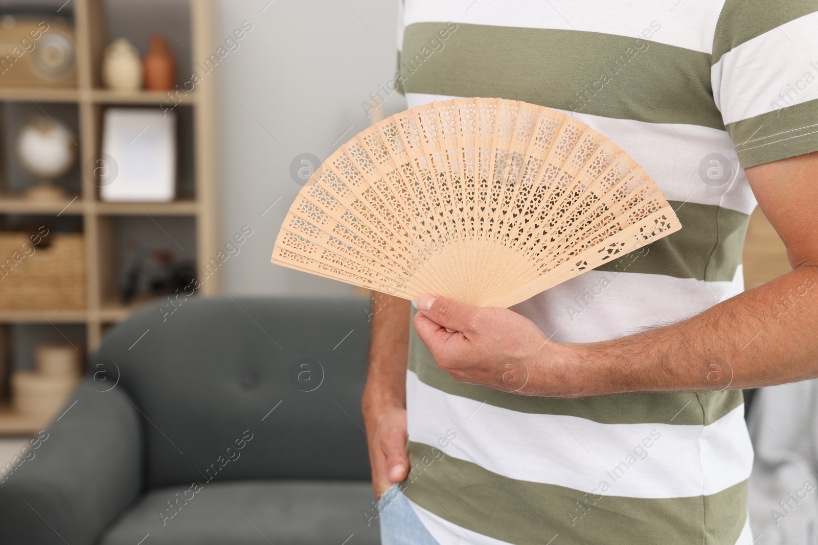 Photo of Man with hand fan at home, closeup