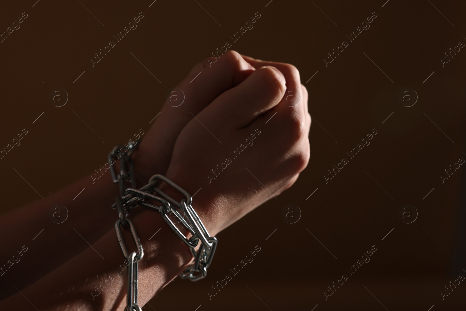 Photo of Little boy with tied arms taken hostage on dark background, closeup. Space for text