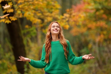Photo of Portrait of happy woman enjoying autumn in park