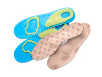 Photo of LIght blue and beige orthopedic insoles on white background, top view