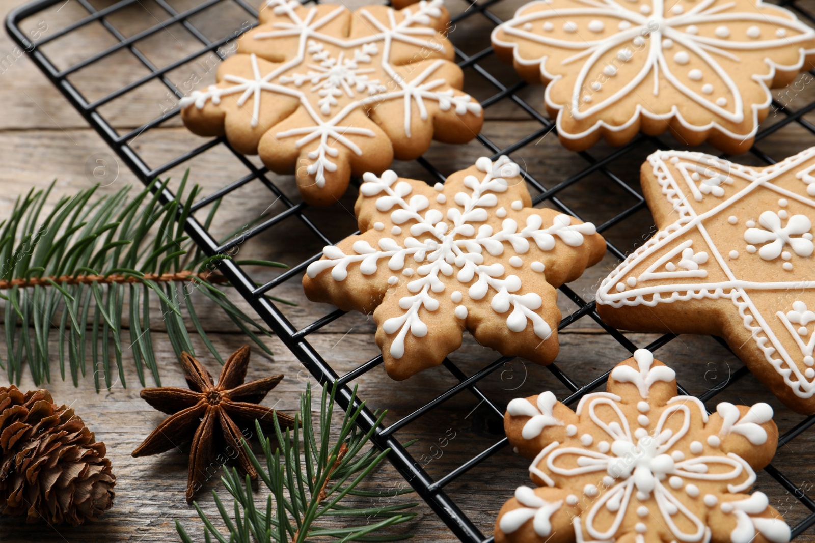 Photo of Tasty Christmas cookies, fir branches, cone and anise on wooden table, closeup
