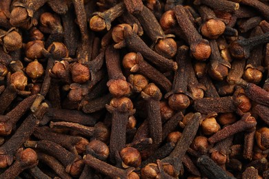 Photo of Aromatic dry cloves as background, top view