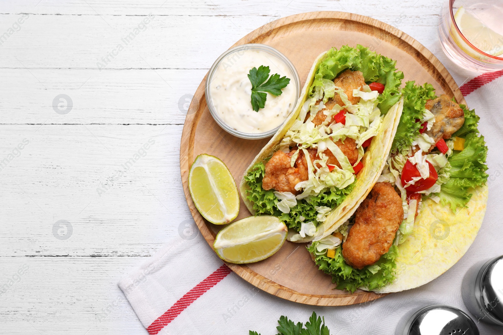 Photo of Delicious fish tacos served on white wooden table, flat lay