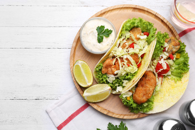 Photo of Delicious fish tacos served on white wooden table, flat lay