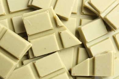 Photo of Pieces of tasty matcha chocolate bars as background, top view