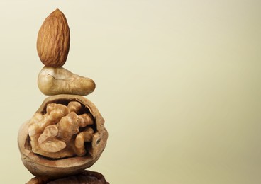 Image of Stacked different nuts on beige gradient background, space for text