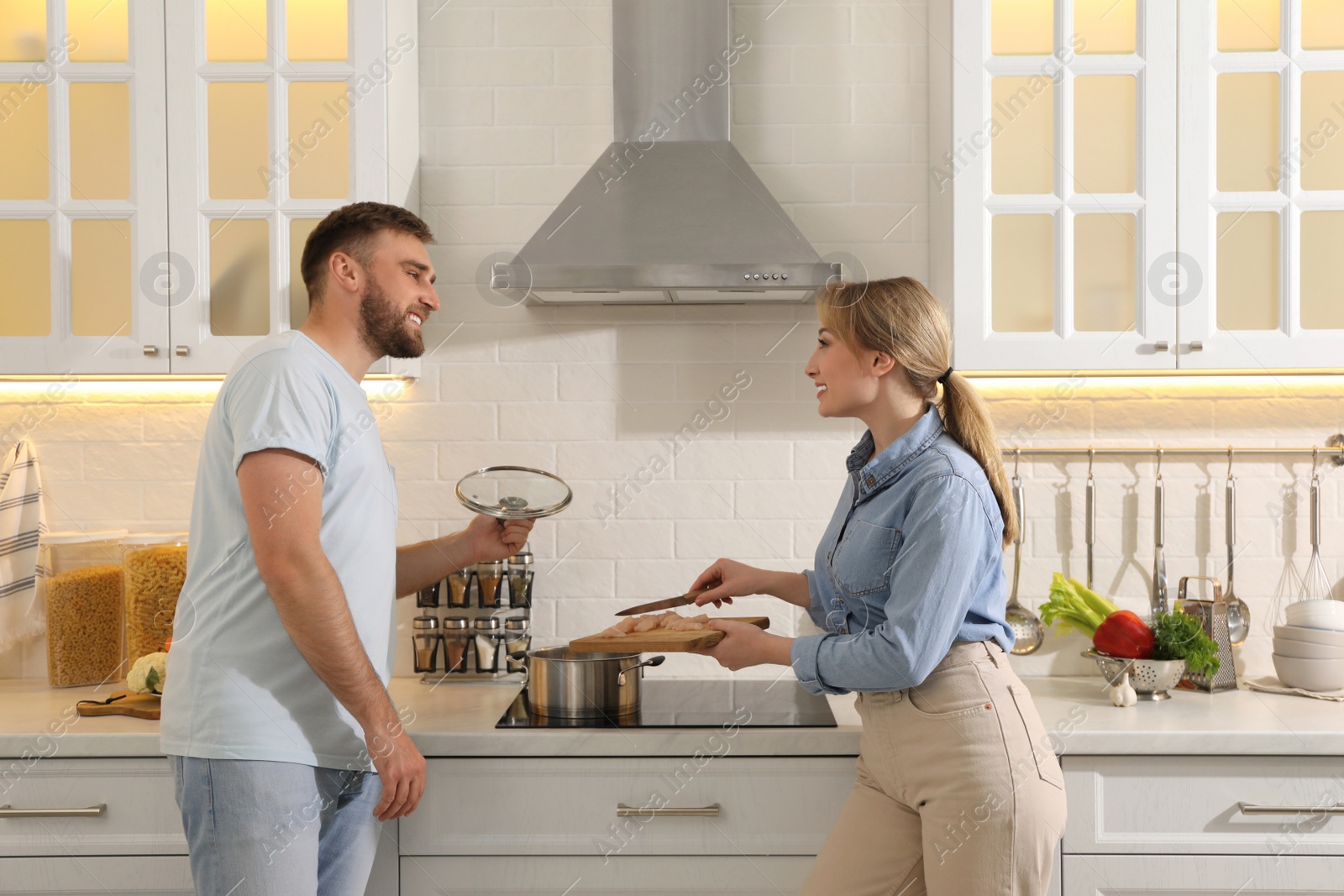 Photo of Young couple making delicious bouillon together in kitchen. Homemade recipe