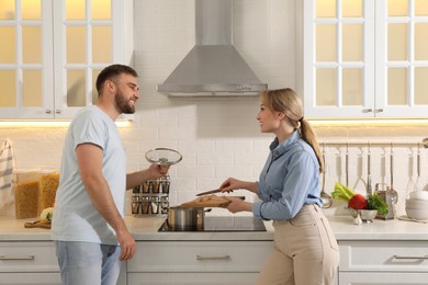 Young couple making delicious bouillon together in kitchen. Homemade recipe