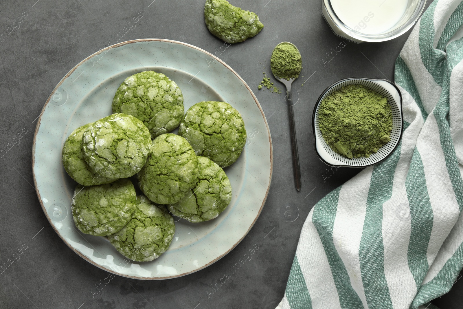 Photo of Tasty matcha cookies, powder and milk on grey table, flat lay