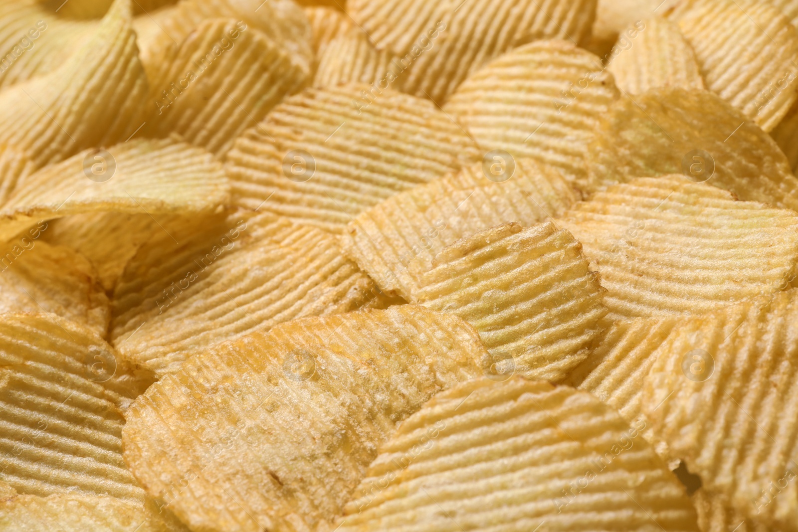 Photo of Pile of crispy potato chips as background, closeup