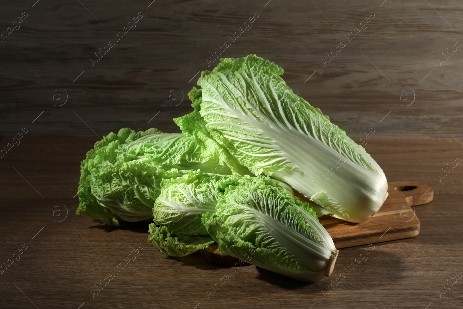 Photo of Fresh ripe Chinese cabbages on wooden table