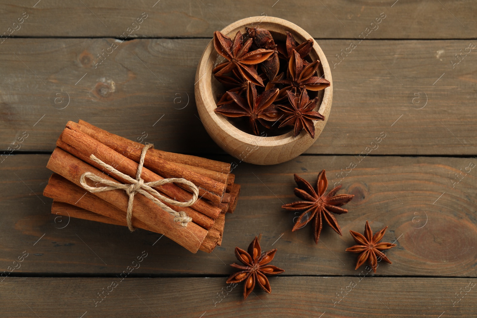 Photo of Cinnamon sticks and star anise on wooden table, flat lay