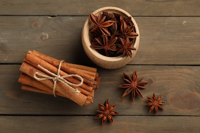Cinnamon sticks and star anise on wooden table, flat lay
