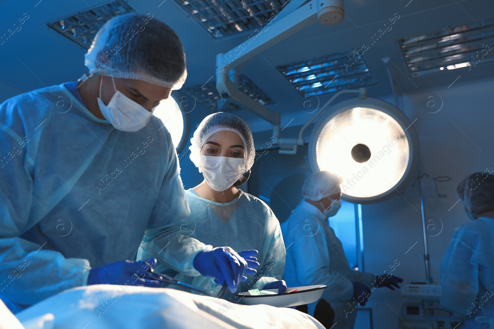 Photo of Team of professional doctors performing operation in surgery room