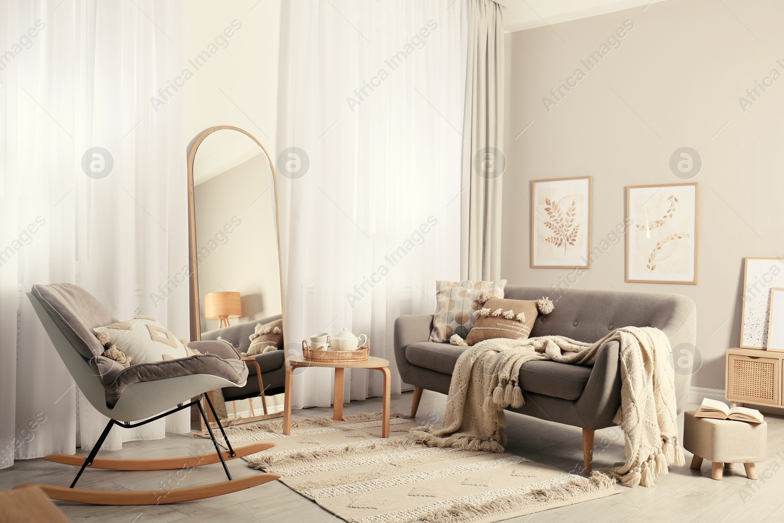 Photo of Stylish living room interior with large mirror, comfortable sofa and rocking chair