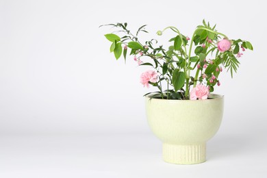 Photo of Beautiful ikebana for stylish house decor. Floral composition with fresh flowers and branches on white background, space for text