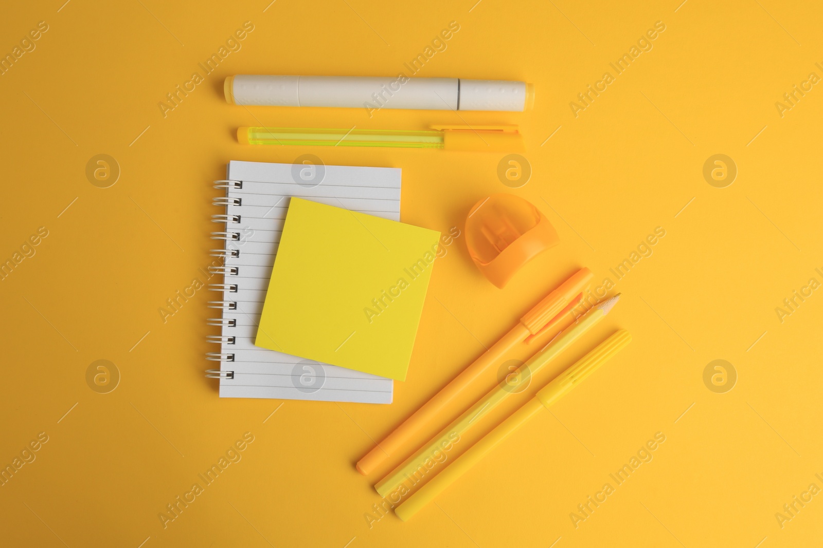 Photo of Flat lay composition with notebook and different school stationery on yellow background, space for text. Back to school