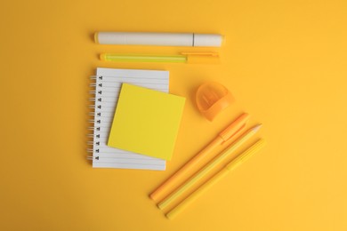Photo of Flat lay composition with notebook and different school stationery on yellow background, space for text. Back to school