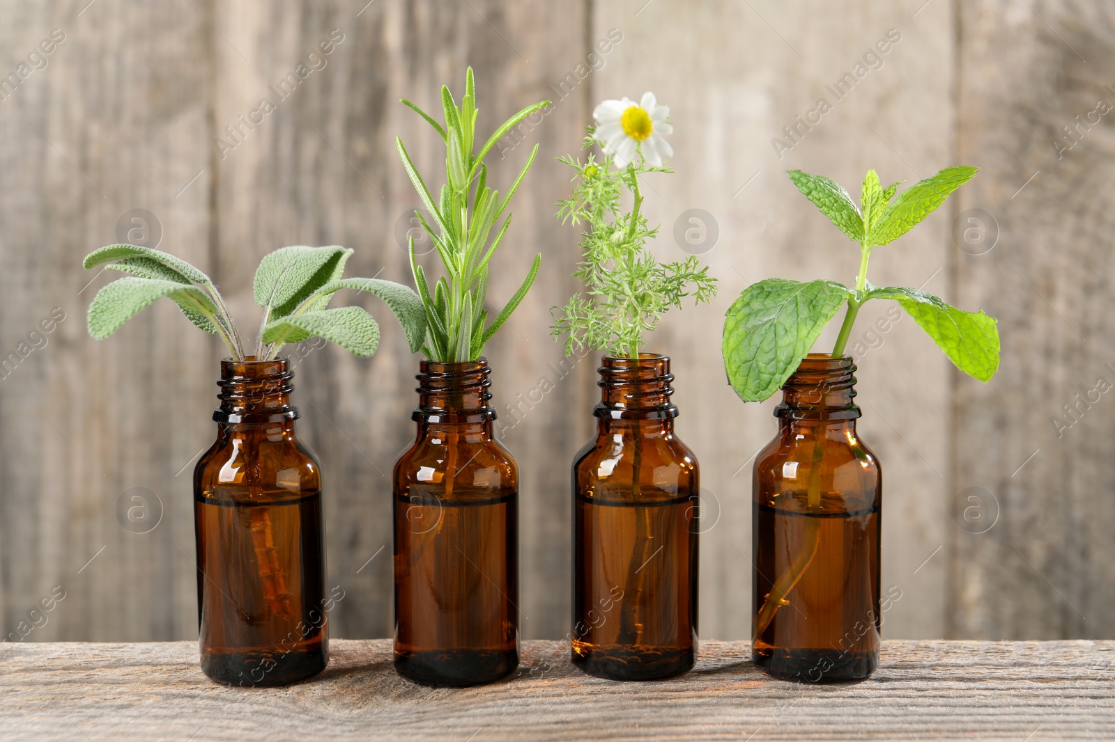 Photo of Bottles with essential oils and plants on wooden table