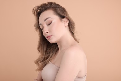 Photo of Portrait of beautiful woman on beige background