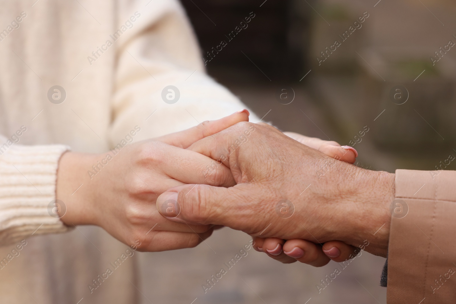 Photo of Trust and support. People joining hands outdoors, closeup