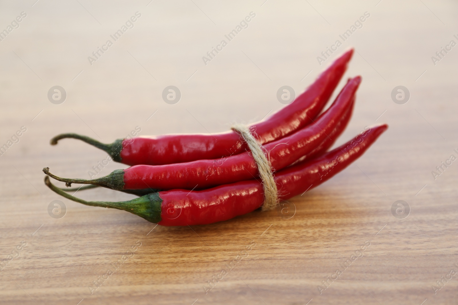 Photo of Red ripe chili peppers on wooden table