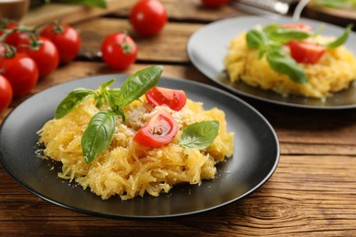 Photo of Tasty spaghetti squash with tomatoes and basil served on wooden table