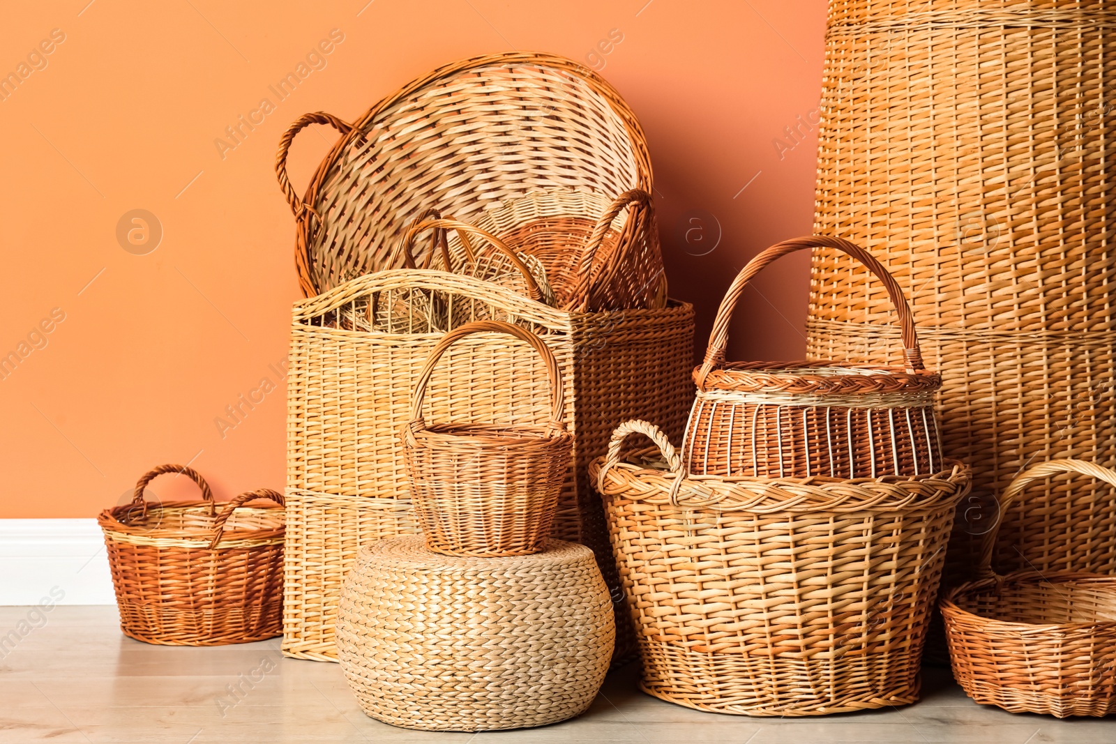Photo of Many different wicker baskets on floor near coral wall