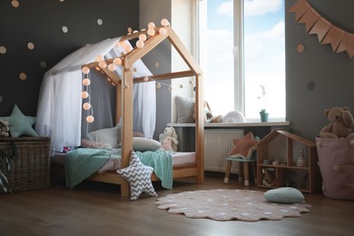 Photo of Stylish child room interior with house bed and different toys