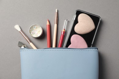 Photo of Set of makeup products with bag on grey background, flat lay