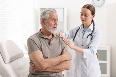 Photo of Arthritis symptoms. Doctor examining patient with shoulder pain in hospital