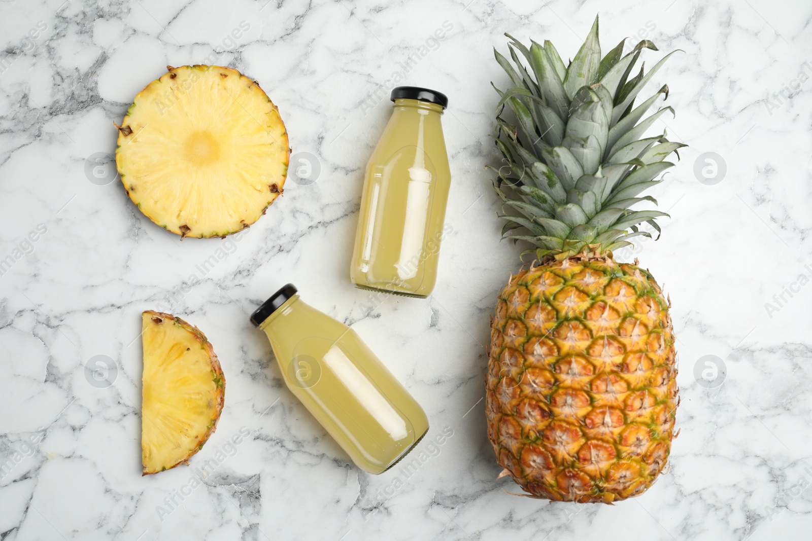 Photo of Delicious pineapple juice and fresh fruit on white marble table, flat lay