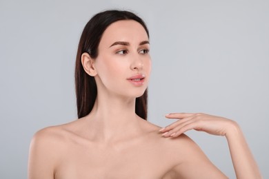 Portrait of beautiful young woman on light grey background