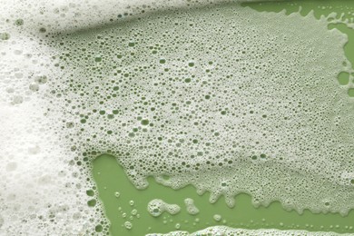 Photo of White washing foam on olive background, top view