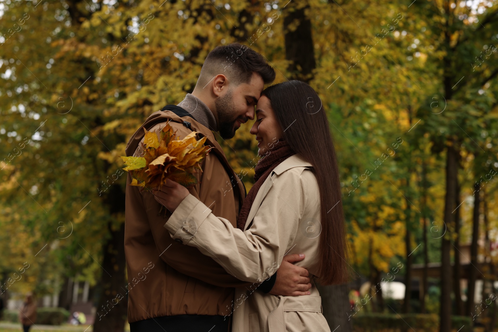 Photo of Happy young couple spending time together in autumn park