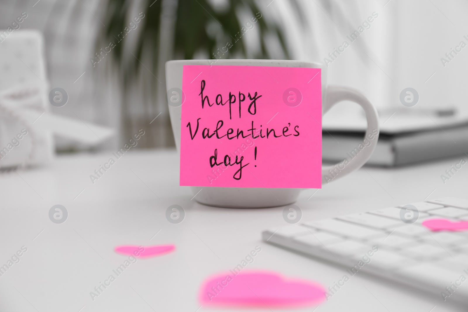 Photo of Memory sticker with phrase Happy Valentine's Day on cup at workplace