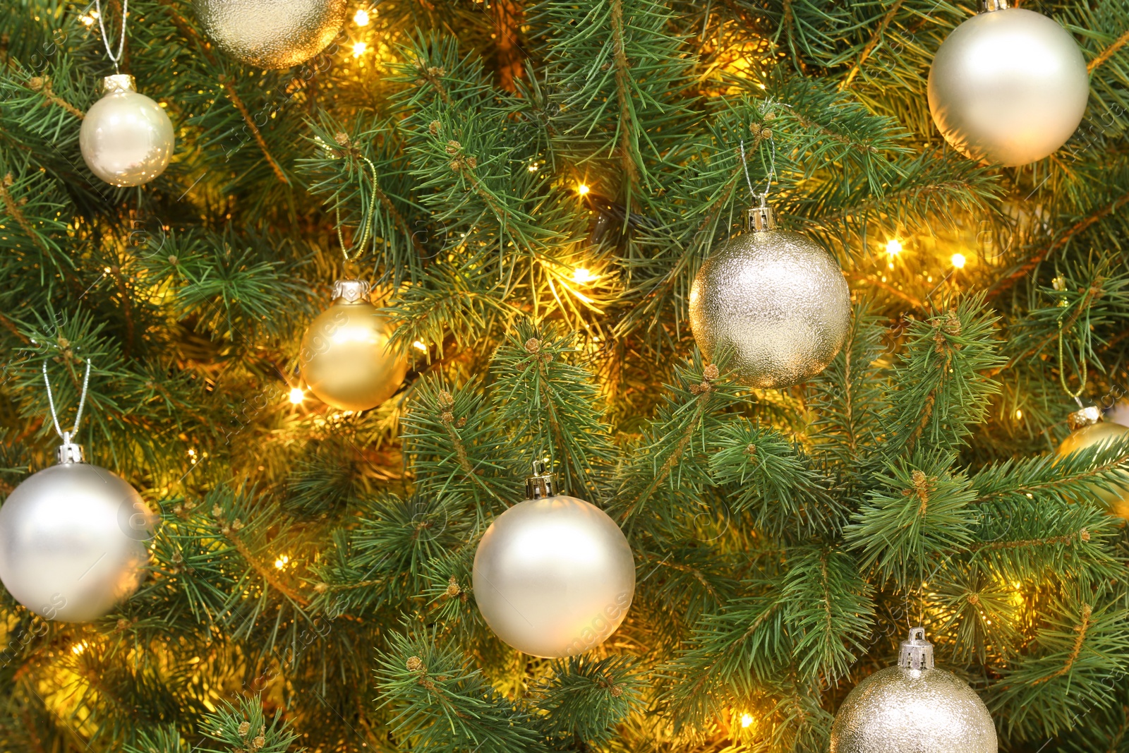 Photo of Glowing bright fairy lights and beautiful baubles on Christmas tree