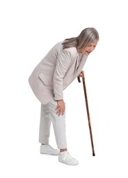 Photo of Senior woman with walking cane suffering from knee pain on white background