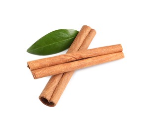 Photo of Cinnamon sticks and green leaf isolated on white